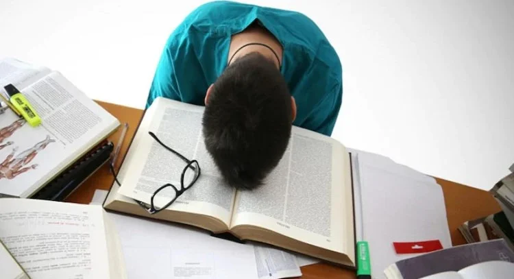 طالب يبدو مرهقاً وواجه صعوبة التركيز أثناء الدراسة، يمثل تحدياً يتناوله مقال نصائح لتحسين التركيز.