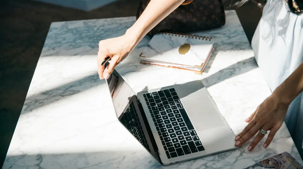 أيدٍ تعمل على حاسوب محمول يوضح استراتيجية التسويق بالمحتوى للشركات الناشئة