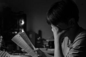 طالب يعاني من الإرهاق الذهني وصعوبة التركيز أثناء القراءة، يمكن أن يستفيد من تقنيات الاسترخاء الذهني